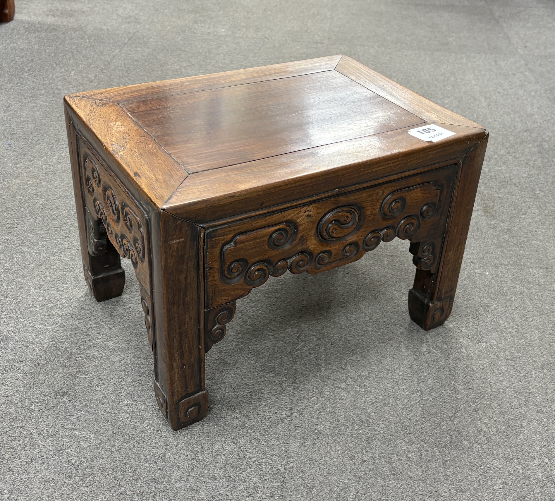 A Chinese low rectangular hardwood stand carved with scrolls, width 37cm, depth 28cm, height 26cm